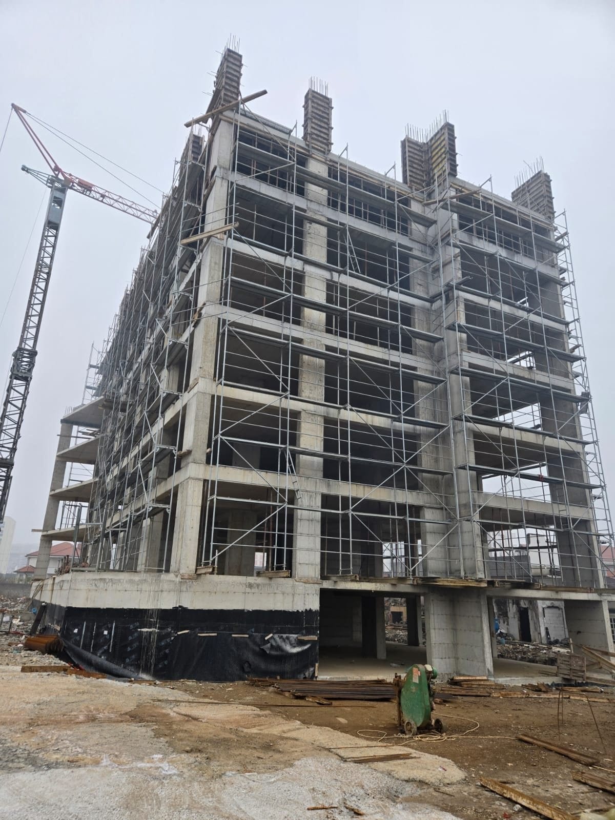 Elysium Series 1 on site: the concrete frame rising floor by floor with scaffolding and a tower crane.